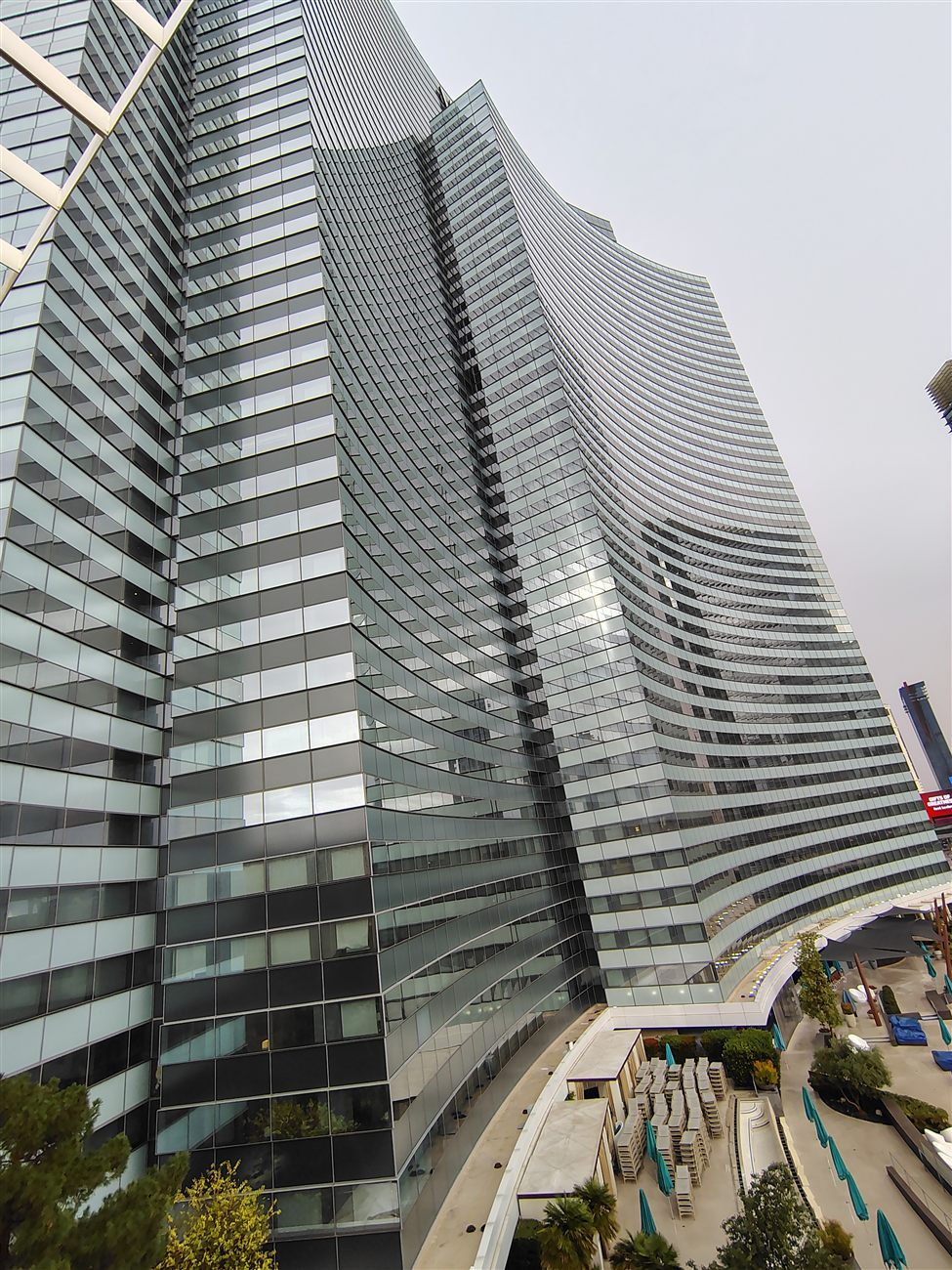 Looking straight up at a curved glass skyscraper
