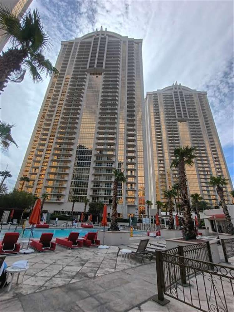 Twin residential towers seen from a pool deck at golden hour