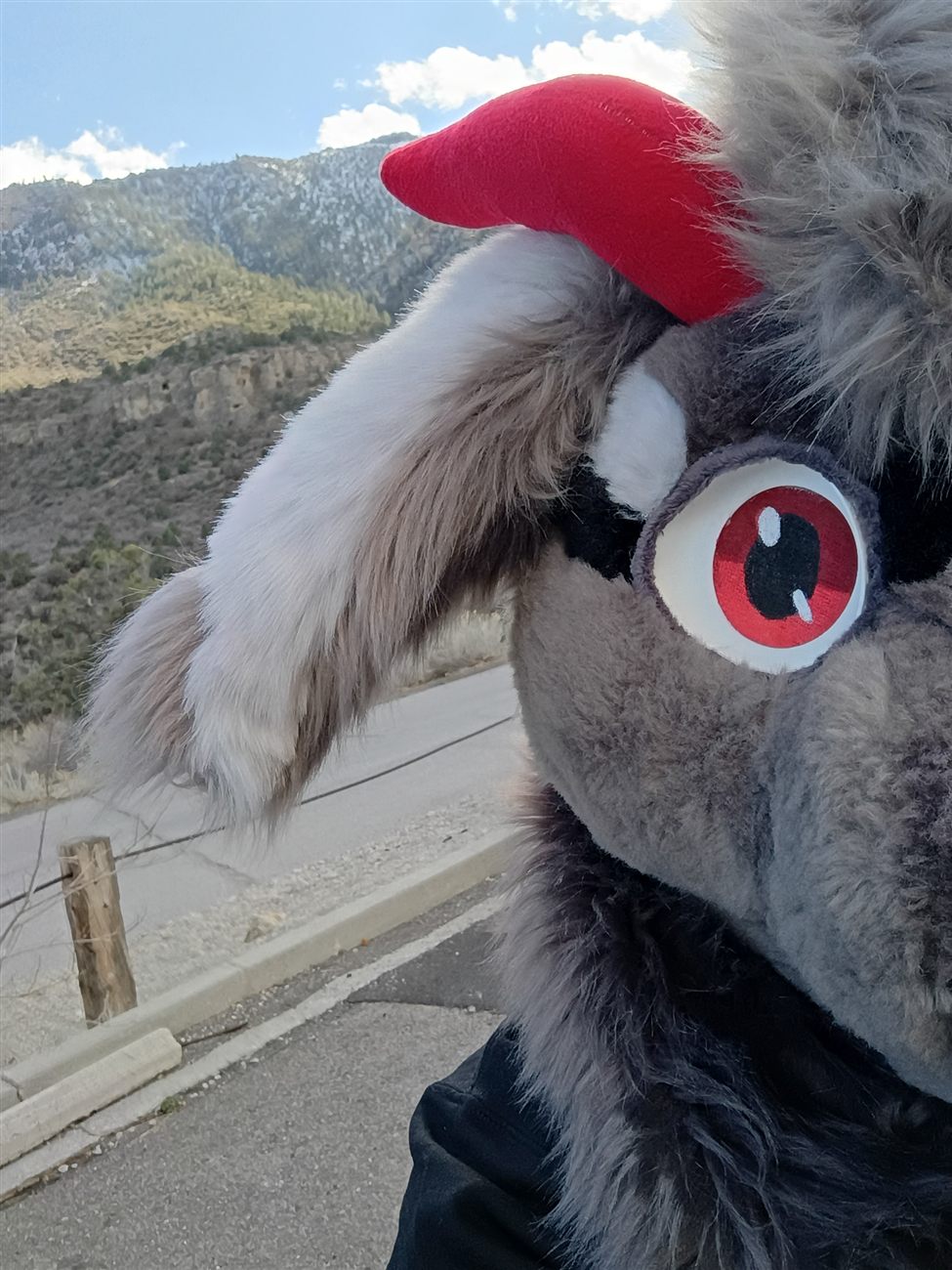 Profile view of the grey premade fursuit head's ear and eye