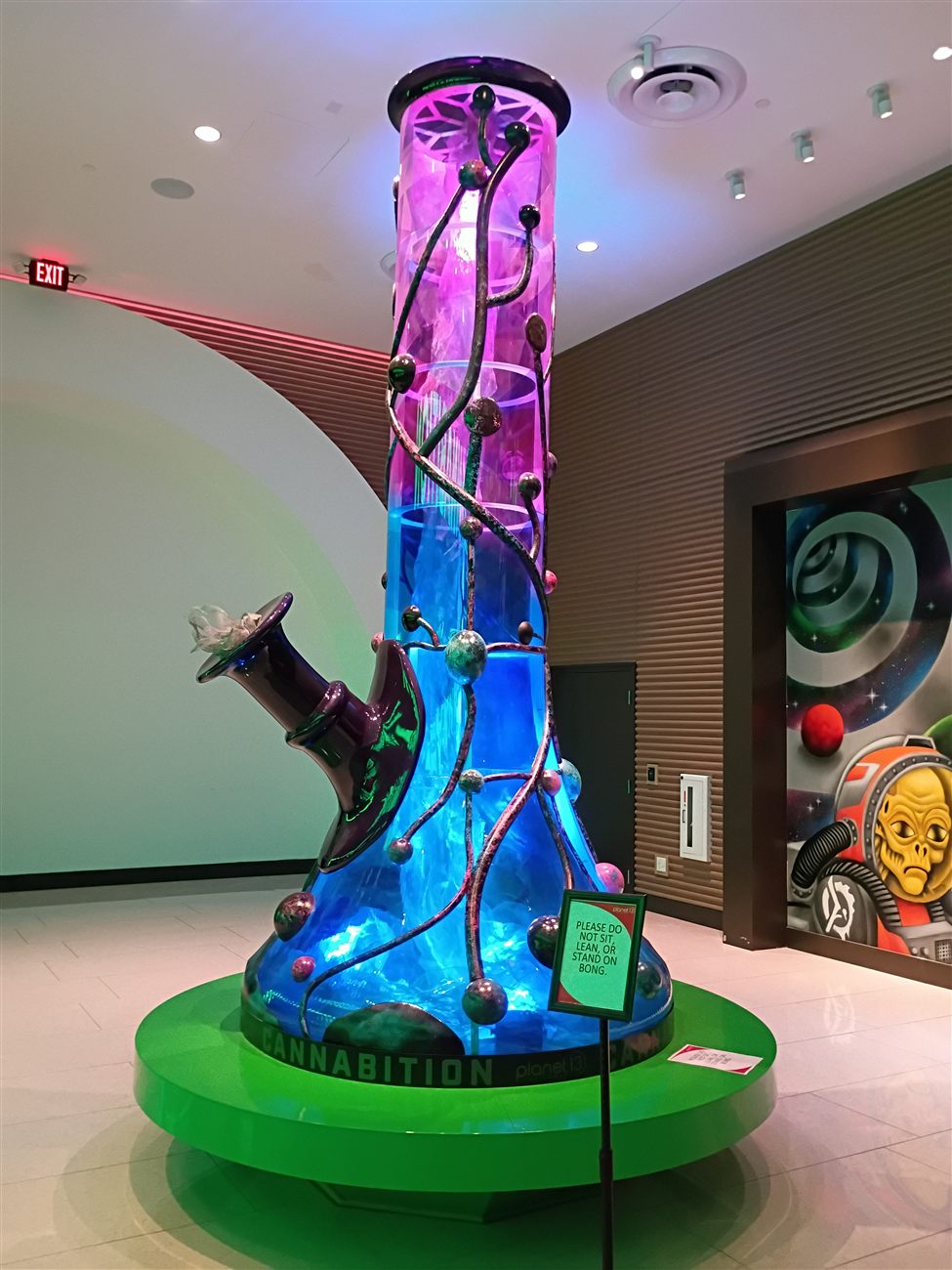 A giant illuminated bong sculpture lit up in blue and purple