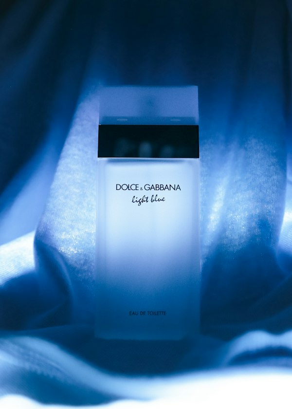 A bottle of Dolce and Gabbana Light Blue against blue draped fabric