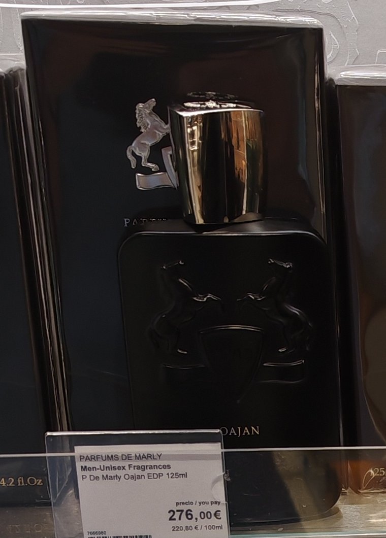 A black bottle of Parfums de Marly Oajan with its box and shelf tag in a store